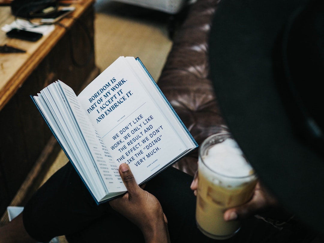 Iemand die rustig een boek leest bij een kop koffie, analoog genieten