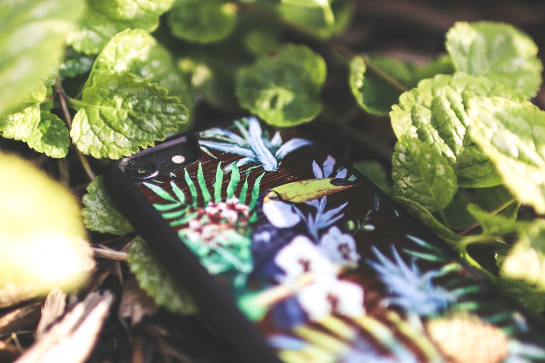 Smartphone met tuin-app tussen bloeiende planten