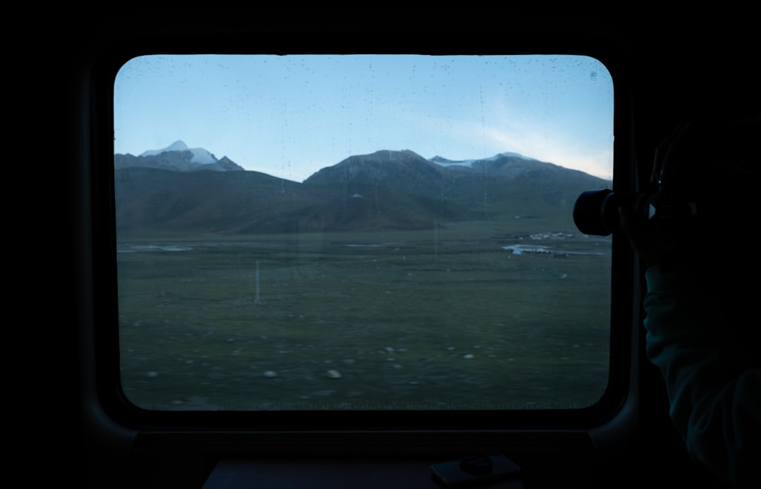 Uitzicht op berglandschap vanuit een treinraam bij zonsopgang